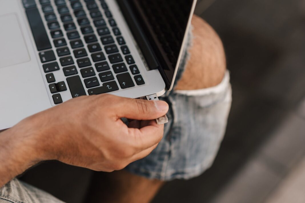 pexels-photo-4792741 male remote worker inserting usb stick into port